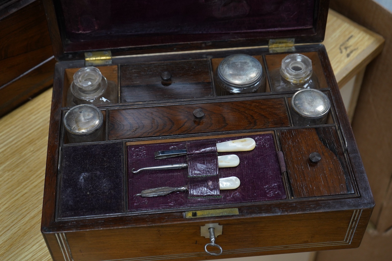 Three 19th century vanity and sewing boxes with fitted interiors to include a mother of pearl inlaid example with glass bottles, jars and mirror, largest 35cm wide. Condition - fair, some losses